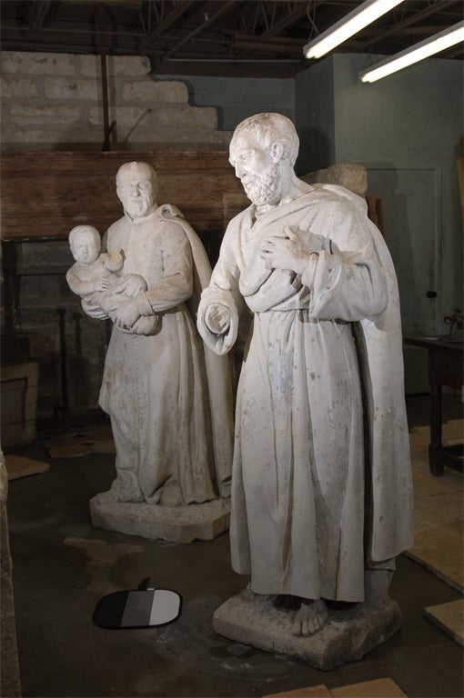 This pair of late 18th century carved stone statues once sat on the grounds of a Monastery in Northern France. The statues are of peaceful looking monks, one is holding a baby. 

These life-size pieces would be an elegant and unique addition to