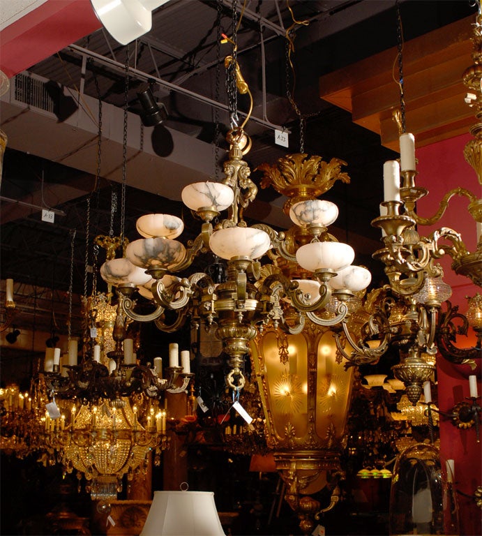 Zwölfflammiger Kronleuchter aus vergoldeter Bronze im Regence-Stil mit Scaglione-Alabasterschirmen.
