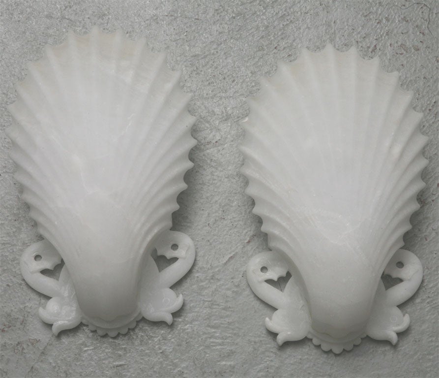 Italian Art Deco Shell plaques carved of alabaster with dolphin motif flanking the bases.  These plaques can be developed into sconces - see all images- by mounting to a simple light source.