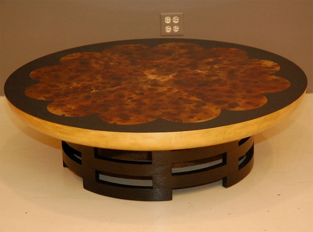 Round gold-leaf drum coffee table with black lacquer asian style base and gilded flower design, tortoise shell top.  Designed by Theodore Muller in collaboration with Isabel Berringer for Kittinger