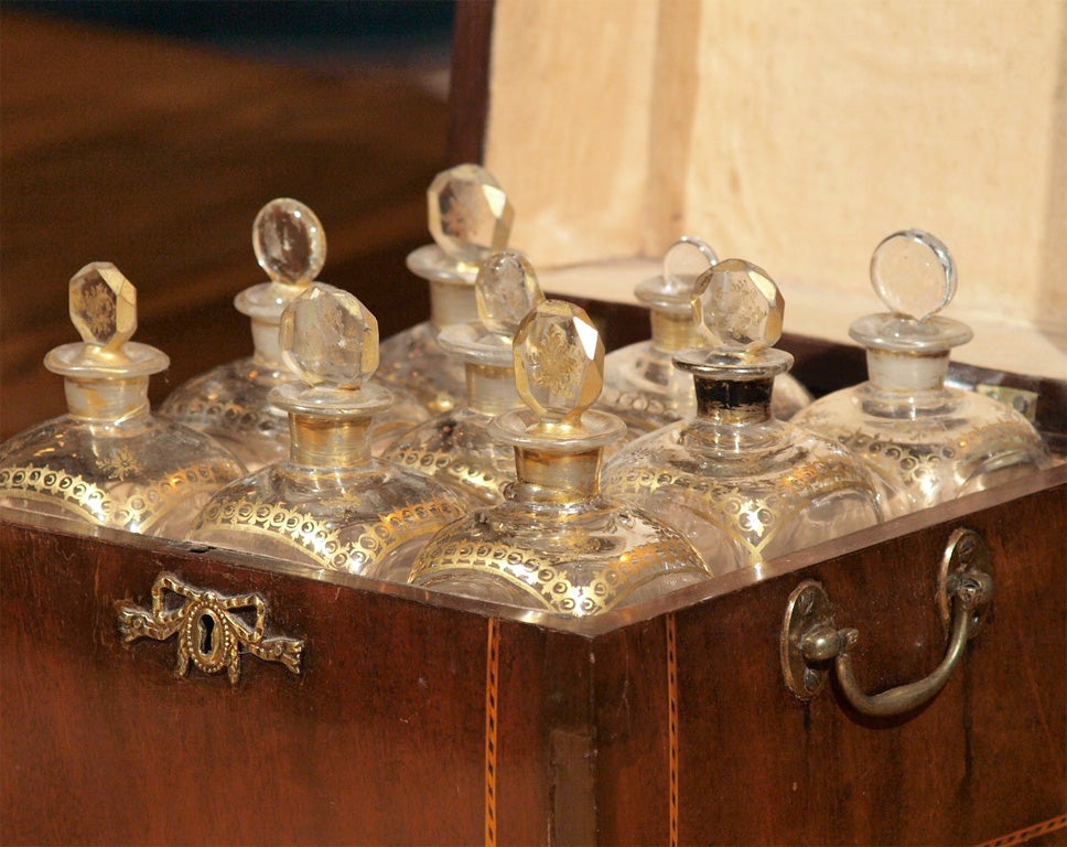 The box with a shell inlay on the top is fitted for the nine hand-blown and gilt decorated period bottles.<br />
<br />
Bottles measure: 7 x 2.5 x 2.5