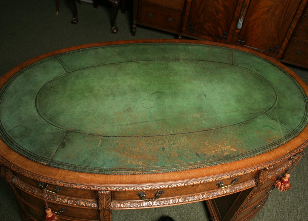 A very good oval or elipse shaped English desk in burr walnut.