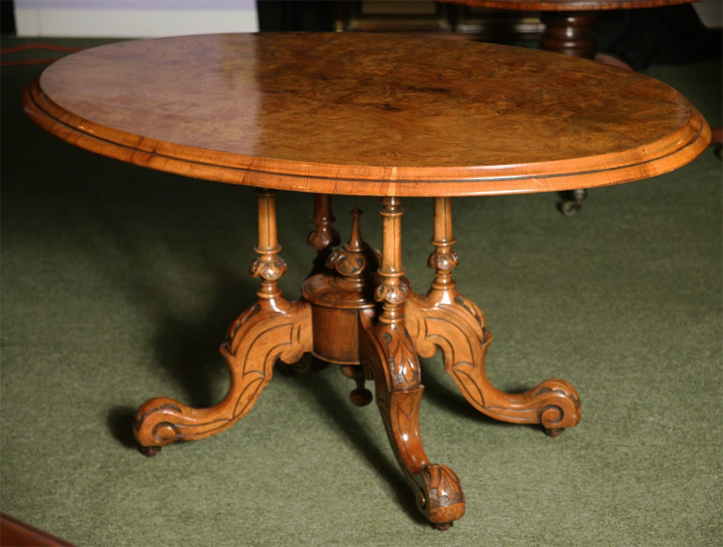 A mid-19th century English tilt - top Walnut Loo Table, the elipse shaped top has a beautiful mellow color to the burr walnut. The table base is of solid walnut and is fitted with a finely turned walnut finial. This type of table got its name from