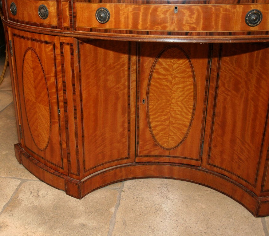 Unusual George III Style Oval partners desk with tooled leather top and rosewood cross banding.