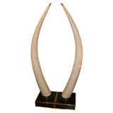 Pair of stone veneer tusks with brass details
