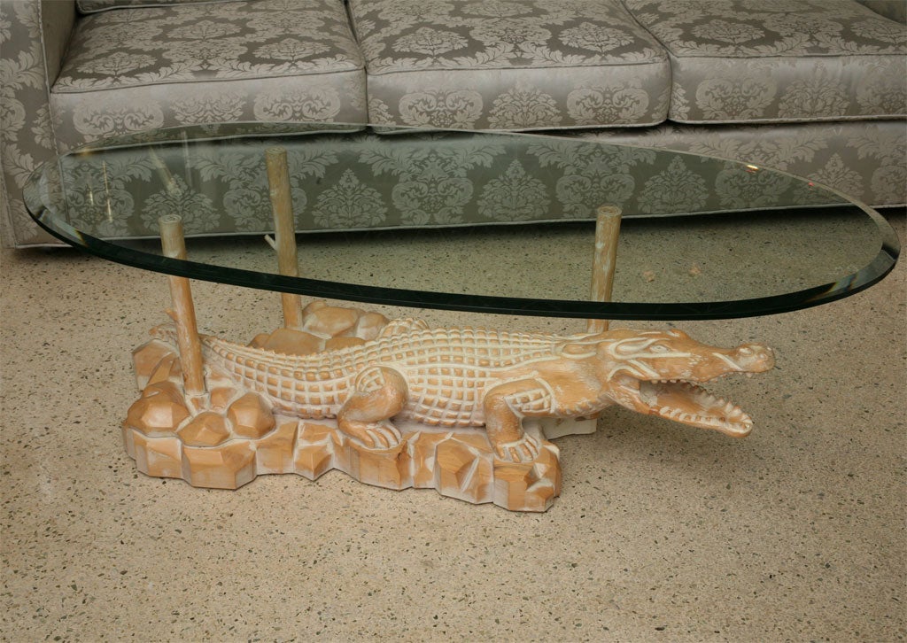 Serge Roche meets Crocodile Dundee! A lovely carved base reminiscient of the French master gets a wry reptilian addition on top. Solid wood with a pickled finish. Oval bevelled glass top balances on three faux branches (one floating on its own