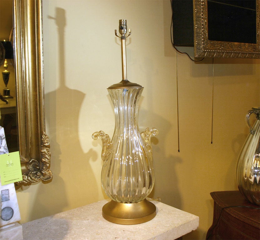 A 1940's overscaled Barovier Murano glass table lamp of neoclassical form with fluted urn shaped pale gold body and two scalloped handles with deeper gold inclusions. Gold tone metal mounts.