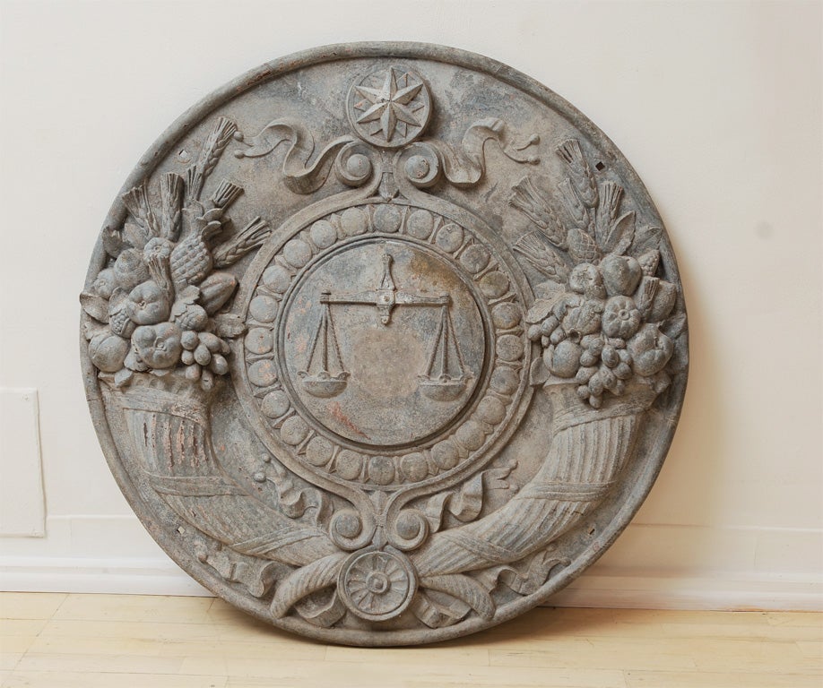 Large round cast medallion, featuring pair of interlocking cornucopias filled with a harvest bounty, surrounding 