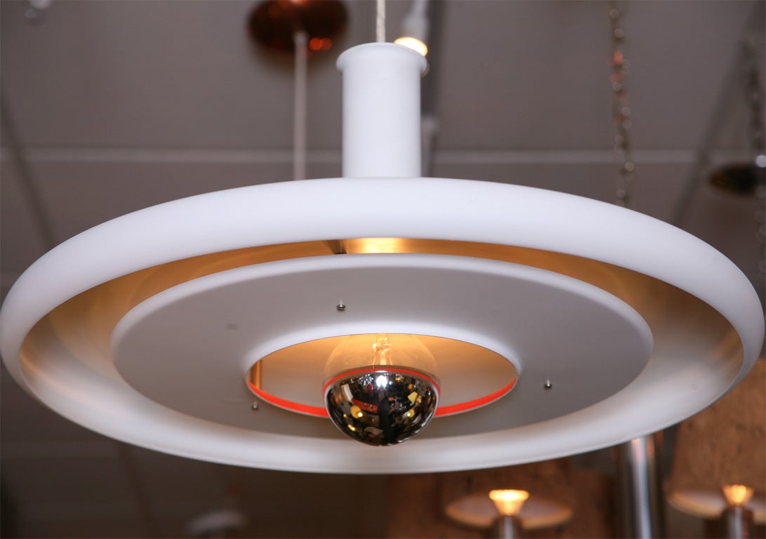 Unusual award winning UFO style pendant light named Optima and designed by Danish architect Hans Due in the late 1960s. Of high quality production by Fog & Morup,  its superb minimal lines are evident in white with orange red center diffuser trim.