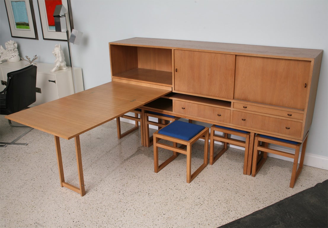 The rectangular case with slides and drawers on a plinth joined by a cross stretcher, with 5 benches fitted under the case, the long drawer opening to reveal a metamorphic folding table/desk dimensions of table/ desk 52