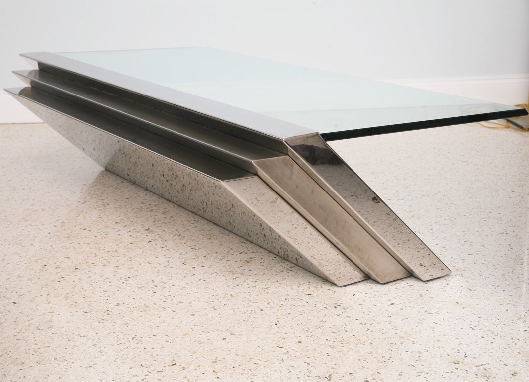 The rectangular glass with beveled edge cantilevered above a stepped polished and brushed chrome angled base
