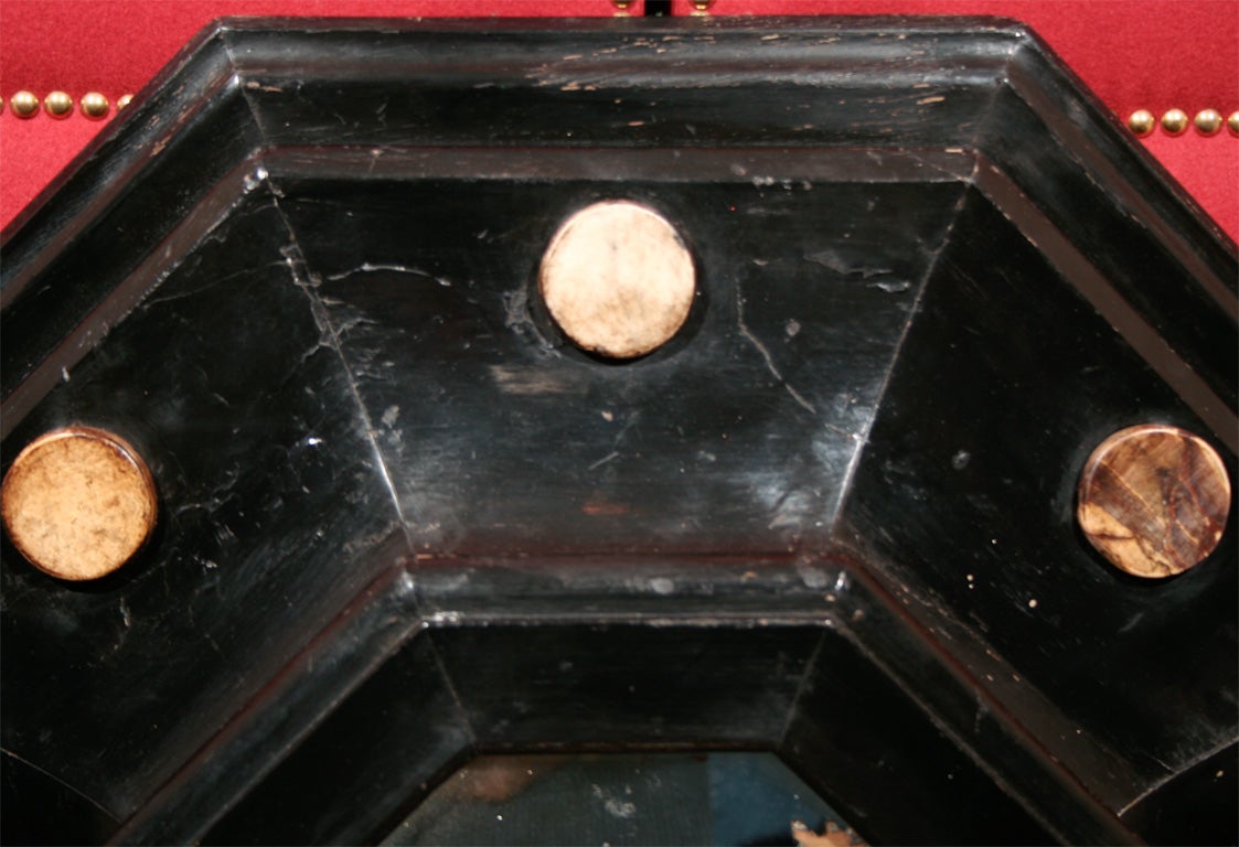 An unusual 19th century octagonal ebonized mirror with multicolored specimen marble medallions along frame surround.
 