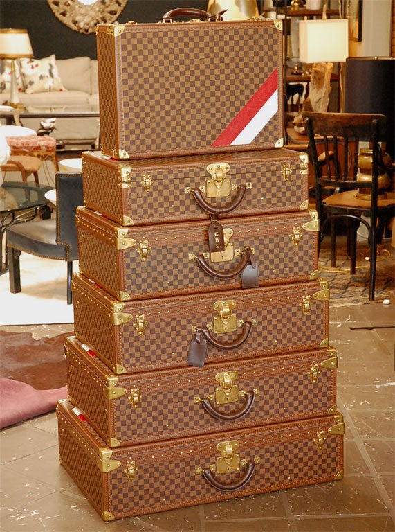 Set of five suitcases in the Damier pattern.  Each case is personalized with a red and white diagonal stripe on the top bottom right corner.  Each suitcase has an individual canvas protection tote.  Suitcases may be purchased individually.  Please