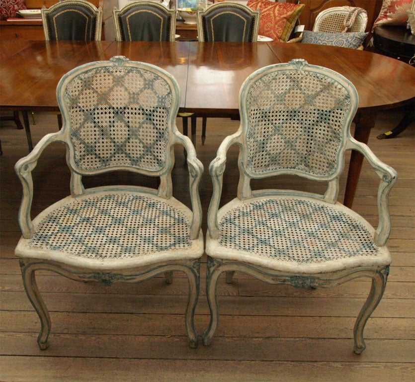 Pair of Painted Cane Seat and Back Louis XV Fauteuils, painted light blue and trimmed in light turquoise, with carved rosettes on top of chair and on the front apron.