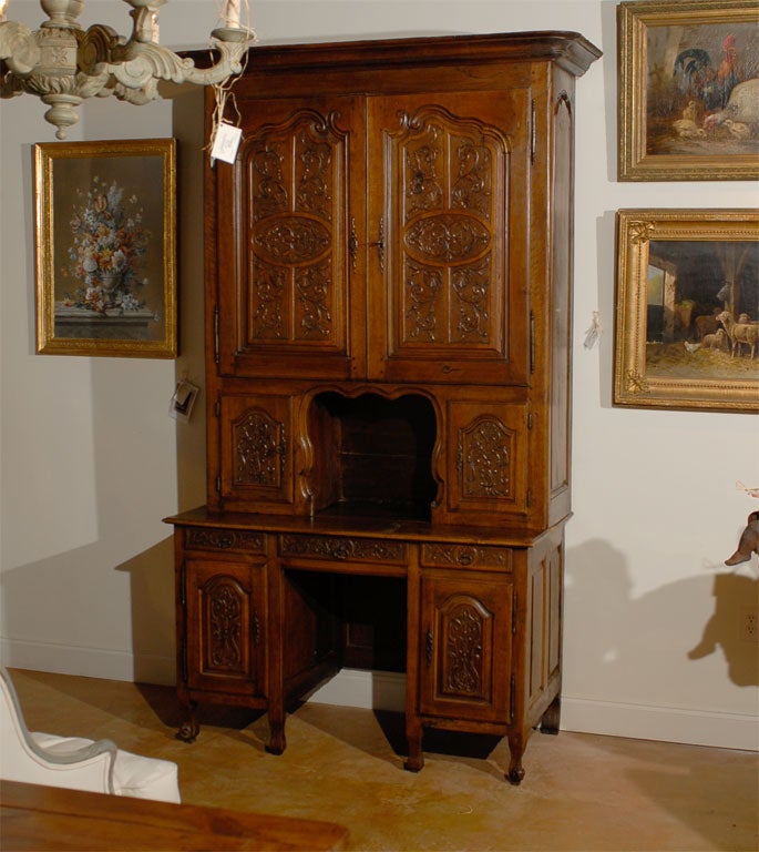 A French late 18th century Louis XV style walnut secretaire bookcase from the Rhône Valley with richly carved panels and knee hole desk. Born in the southeastern region of the Rhône Valley during the later years of the 18th century, this 'secrétaire