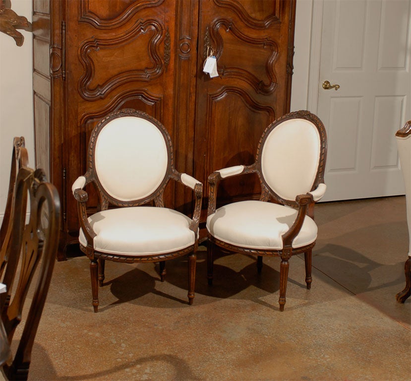 Pair of 19th century French Louis XV carved walnut fauteuil side chairs.
