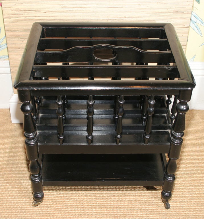 Fine Victorian Renaissance Revival ebonized bobbin turned Canterbury with four divisions separated by turned spindles and a lower shelf on brass castors, English, circa 1860.

Height: 17.5