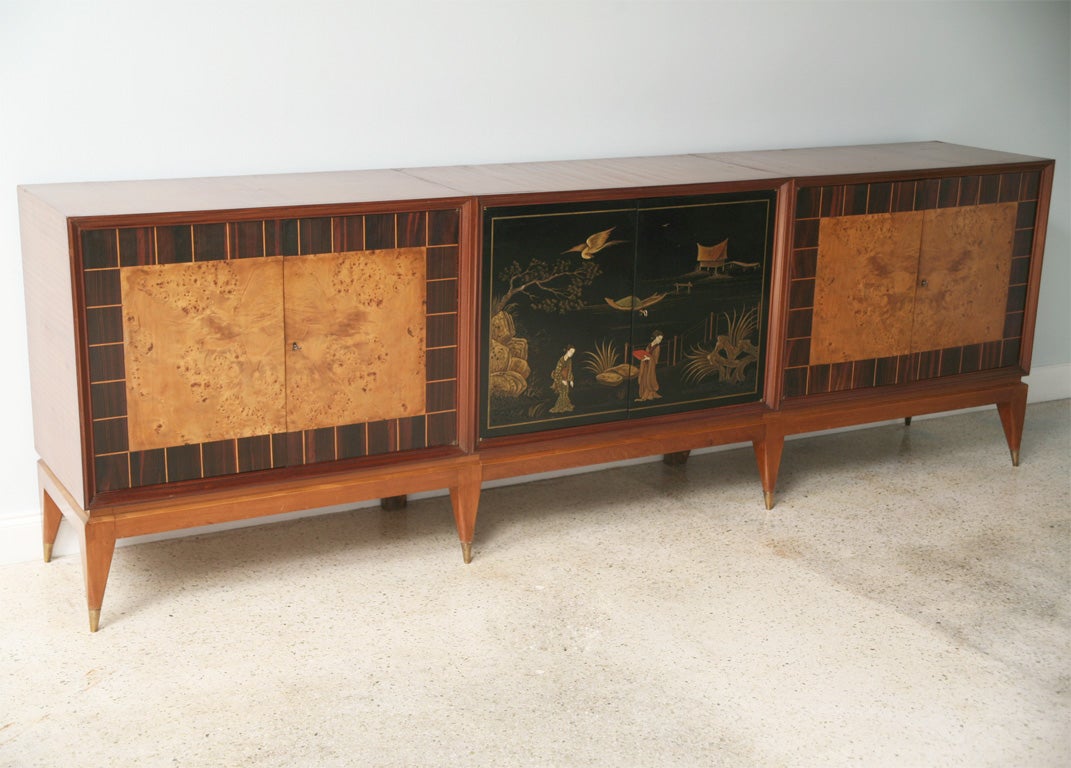 The mahogany rectangular top, sides and legs above two side cabinets with rosewood banding inlaid with lemonwood strips and circassian elm centres, the central cabinet with black lacquer chinoiserie decorated doors, with fitted interiors.