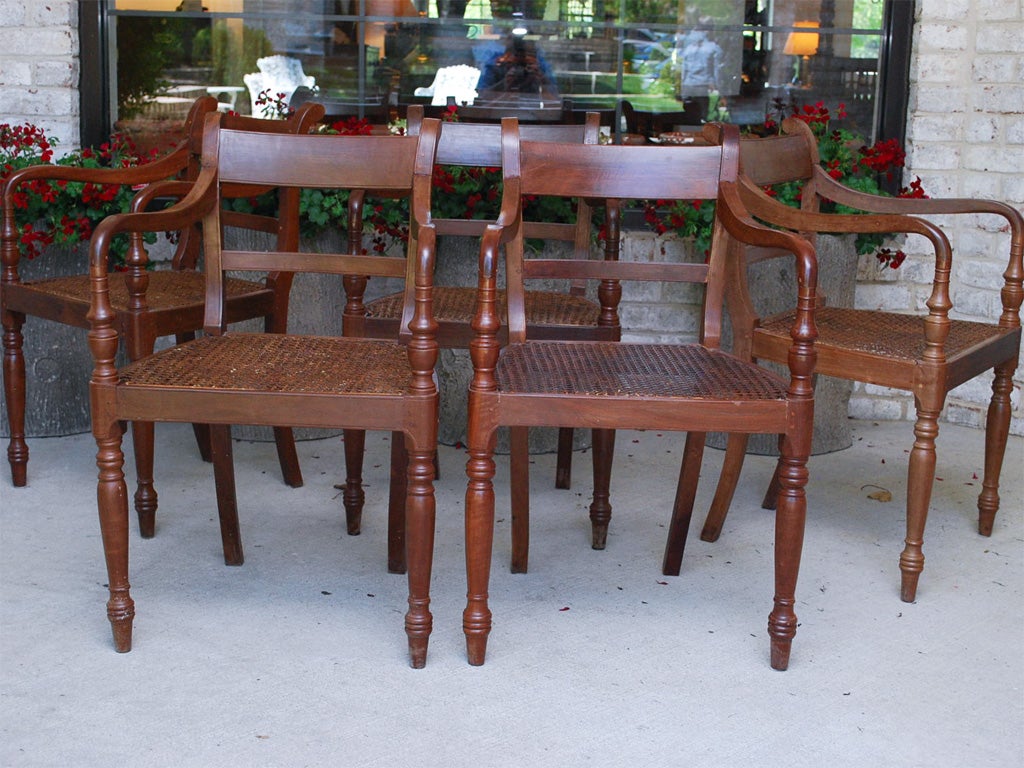 A matched set of ten British Colonial Dining Chairs made in the 19th Century of teak wood with caned seats.
