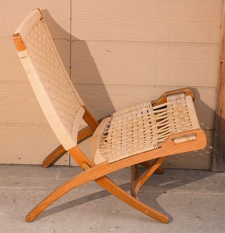 A Hans Wegner Style Folding Chair in the manner of the original Model 512 manufactured by Johannes Hansen for Hans Wegner.  A low sitting, folding Oak Frame with rope seat and back is a great focal point to a room.  Super comfy lounge chair.
