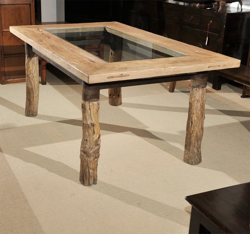 Contemporary one of a kind glass top dining table from China. Made with elm burl root with iron stretcher bar base for the tabletop. Regularly $ 5850, on sale for $ 2195.