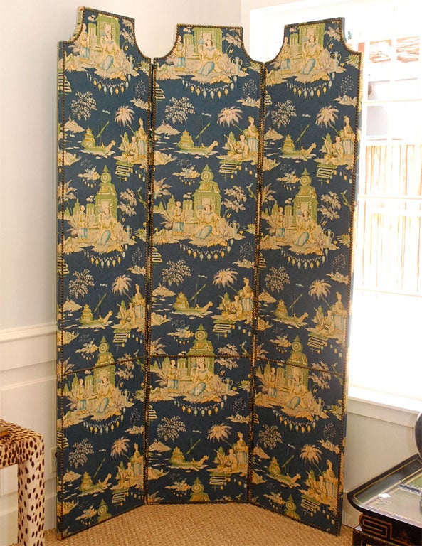 An Upholstered Chinoiserie Screen. Three panel screen upholstered in chinoiserie print linen fabric. Back is upholstered in a matching solid green cotton linen blend with a cream gimp finish.