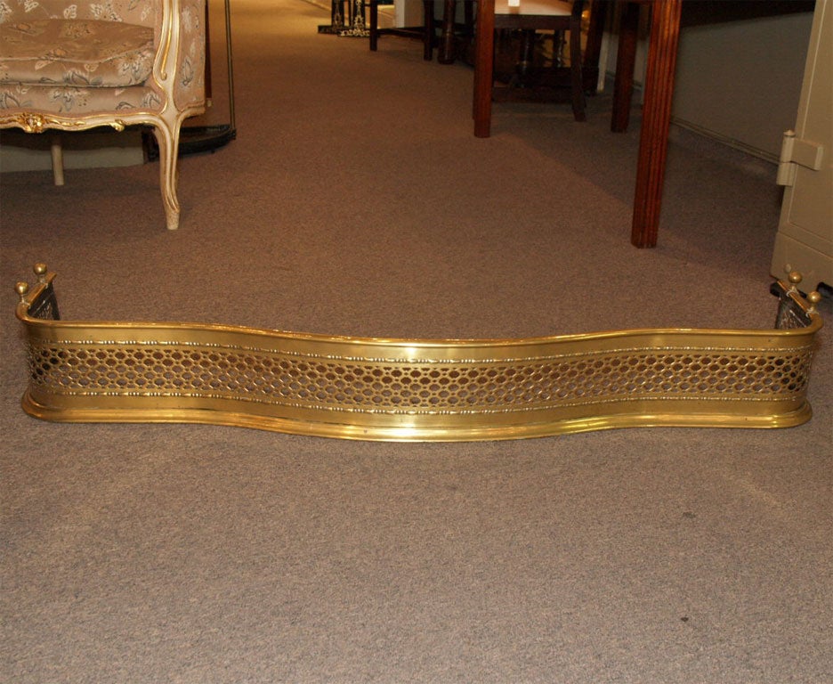 Antique English brass serpentine fender.