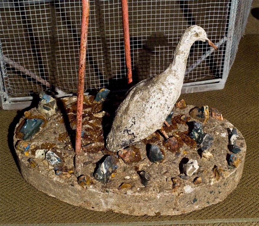 Handcrafted cast stone mother crane and baby crane, on an oval base with inset rocks, original paint.