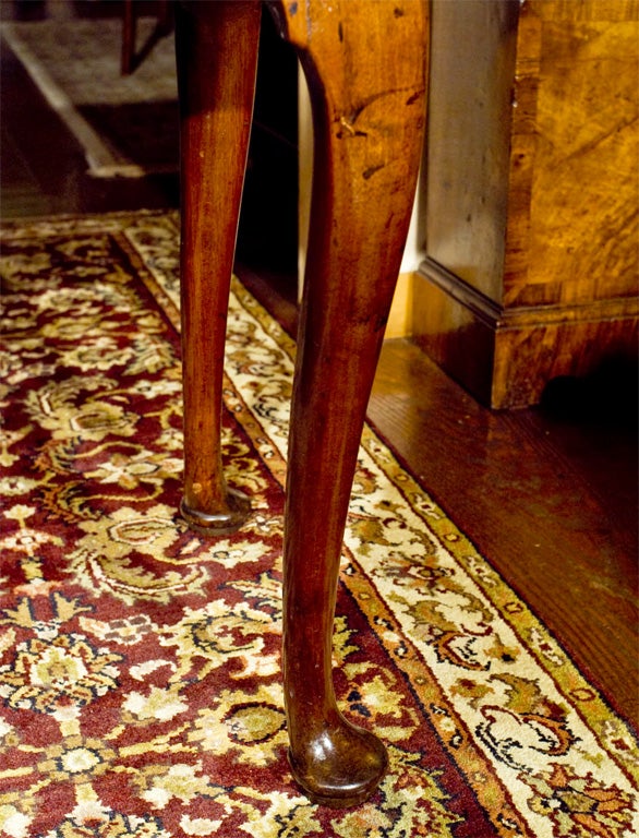 English, solid mahogany Georgian game table on cabriole legs ending in pad feet. Back left leg swings to support open top with felt playing surface. Single oak lined drawer has antique replaced brass swan neck pulls.