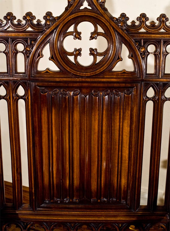 Gothic styled ecclesiastic chair of carved mahogany with tooled leather upholstered seat pad.
