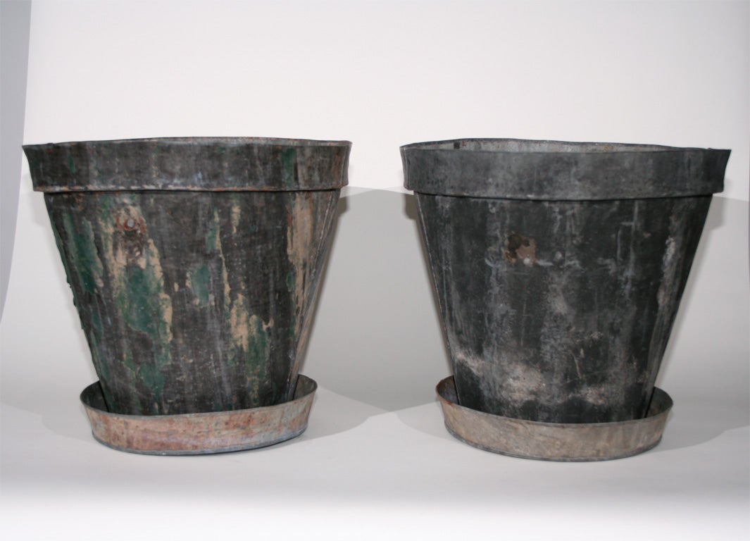 A pair of 20th century large steel cache pots with saucers.