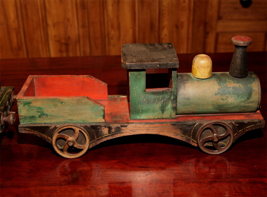 This two car train set was likely made by a doting father for his son. All parts are original and the paint has been touched up in some places on the second car. As a collector of children's toys, this would be perfect on display on top of a buffet
