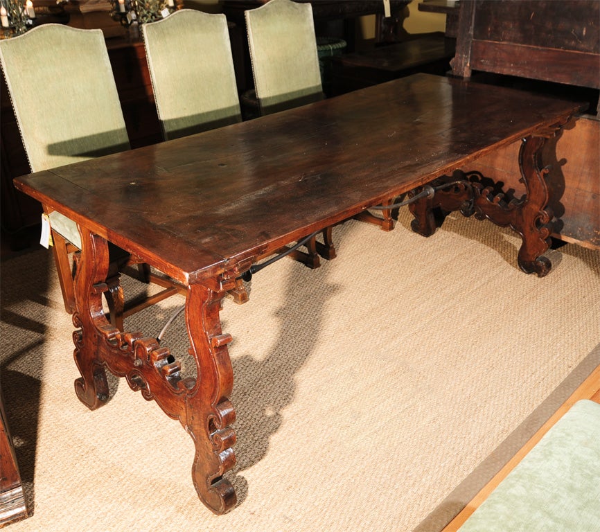 Beautifully carved 18th century Italian dining table, center table, console table or sofa table with hand forged wrought iron trestle support. Gorgeous patina.



 