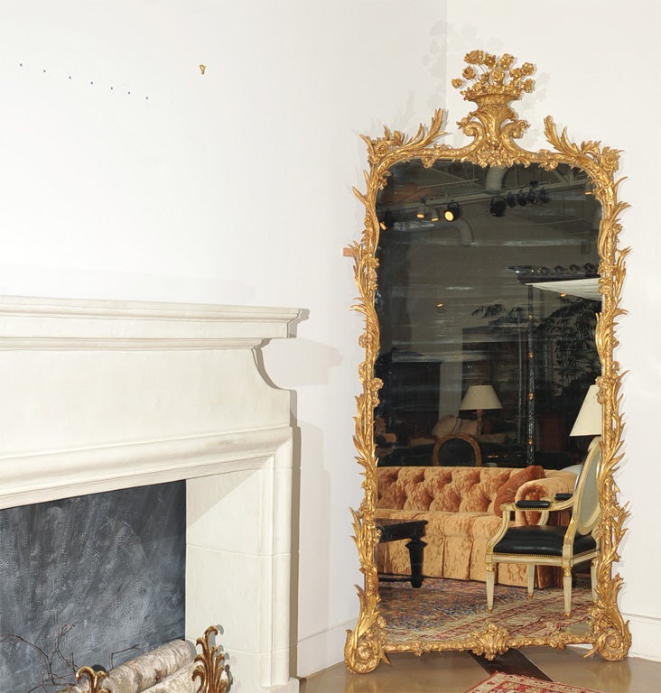 An attractive Rococo painted and gilded Mahogany wood mirror with a wonderful old patination. Large rectangular original central plate surmounted by a carved basket of flowers and surrounded by flowers and garlands swirling around a center carved