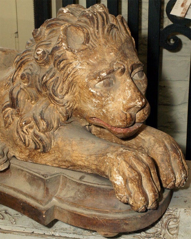 A pair of recumbent lions curved together, set on shaped base.