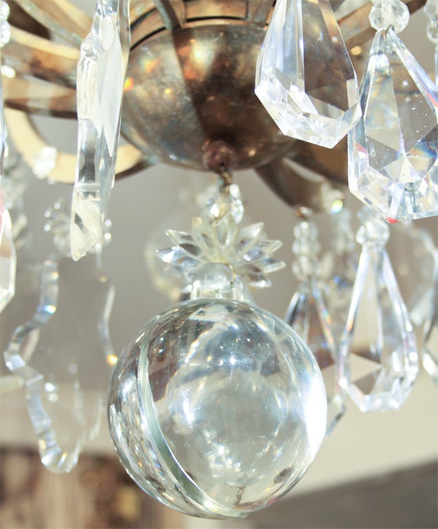 Large French chandelier with 9 lights. Small glass rosettes are embellishing the elegantly curved brass 