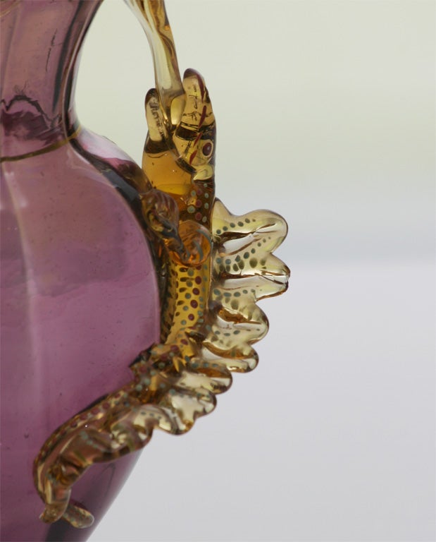 Exceptional pair of hand blown amethyst "Aesthetic Movement" crystal vases with pedestal feet. The amber/topaz applied rims fold down into the open mouths of two life-like lizards wrapped around the body of the vases. Each one is further