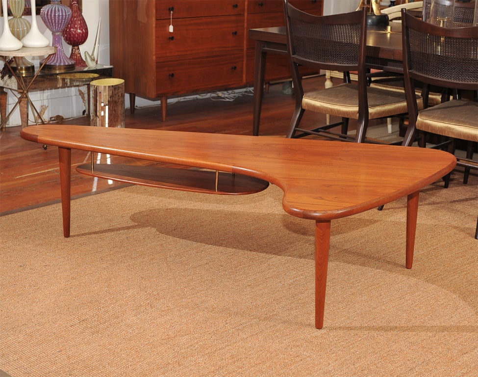 High Quality Danish modern teak boomerang shape coffee table with hanging shelf. Completely restored.