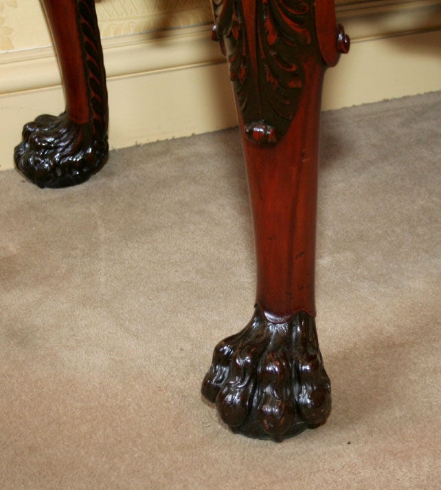 GEORGE II STYLE HEAVILY CARVED MAHOGANY CONSOLE WITH WINGED CHERUBS AND LIONS. SECRET DRAWERS IN BACK.