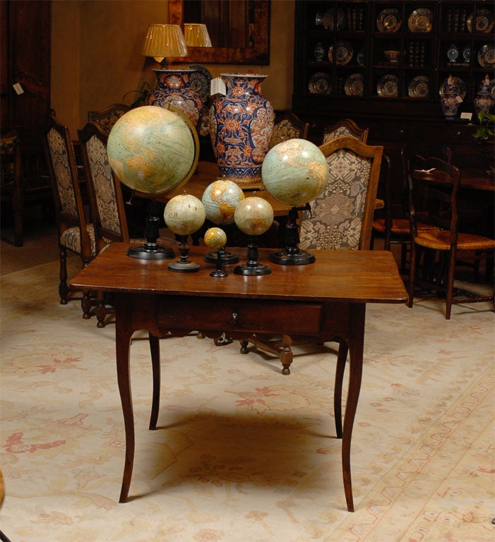 A handsome collection of papier mache terrestrial globes dating from 1880-1900.  All the globes are supported by their original ebonized stands.  In addition, the largest globe has a brass arc that puts the globe in an axis along with a legend