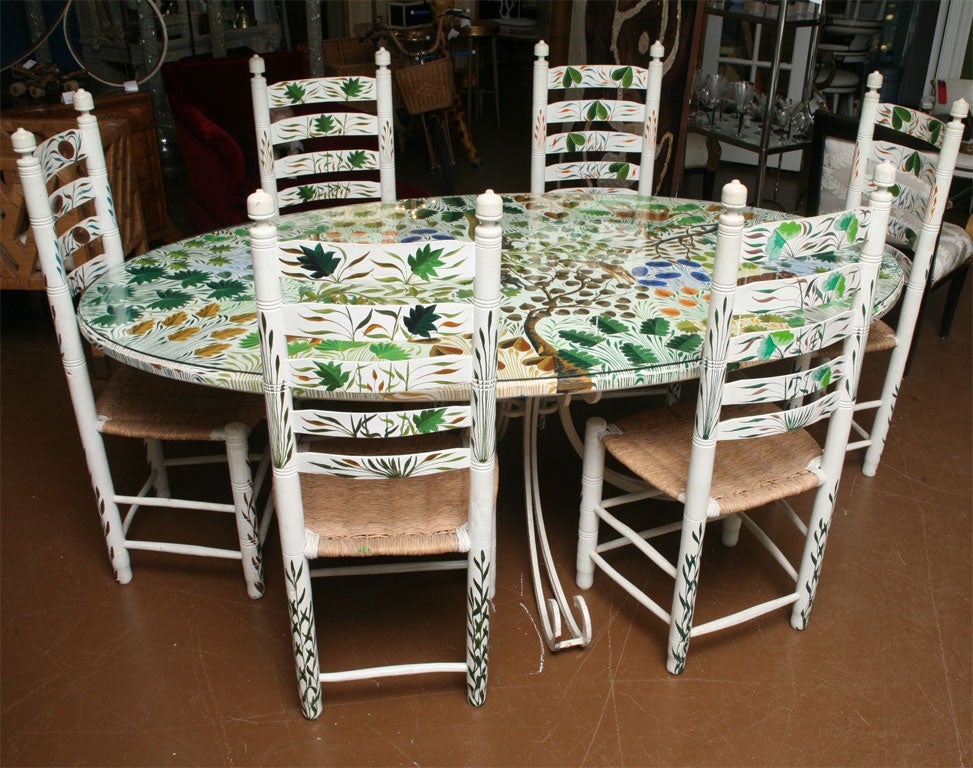 Whimsical hand painted table with metal base and six chairs. Painted with a Rousseau-like jungle scene with giraffes, lions, tigers and elephants. Signed A.G. Calixtes.(keyword:dining set)