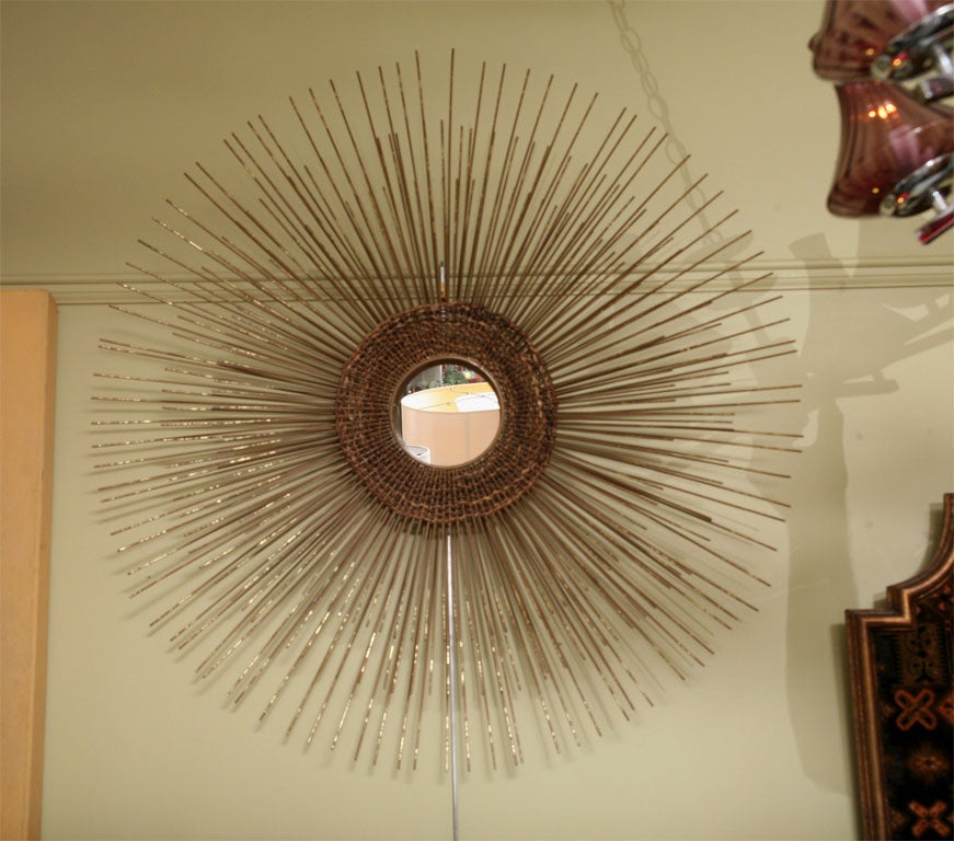 Modernist Sunburst Mirror in the Brutal style of radiating patinated and gold-leafed brass rods with a circular center mirror surrounded by interwoven sisal like rope.  Sunburst or starburst, it is quite striking & unique.  Unsigned but in the