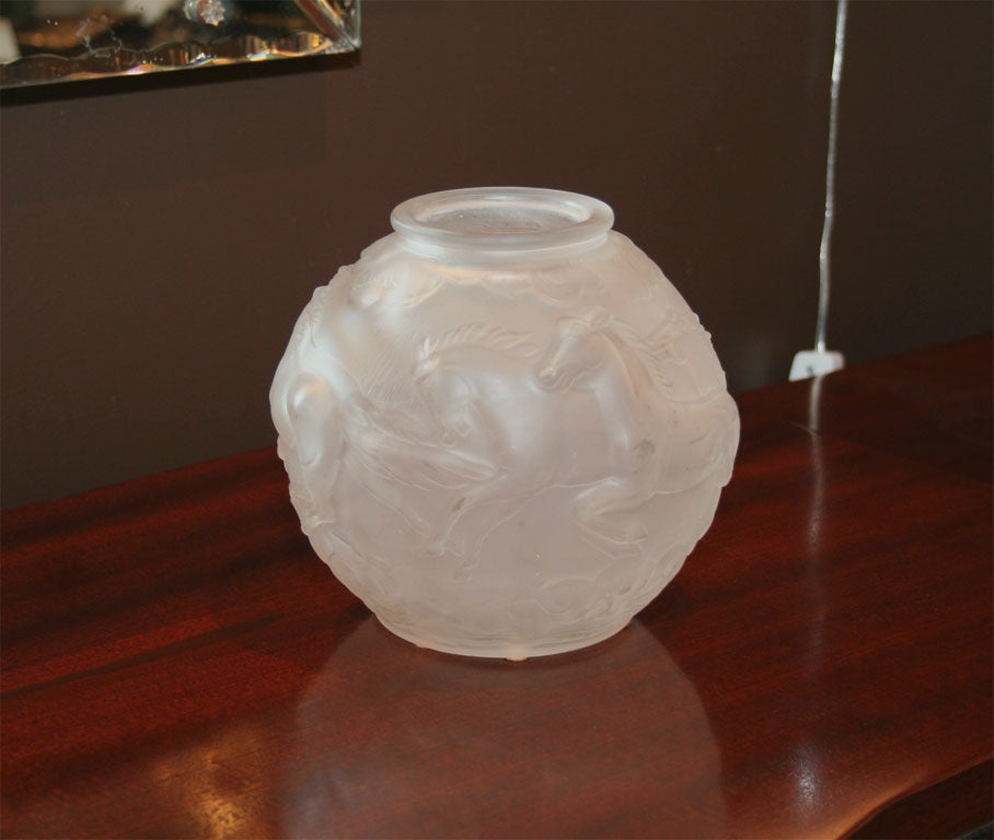 Hand blown and molded frosted<br />
glass vase with stylized<br />
depictions of galloping<br />
horses.