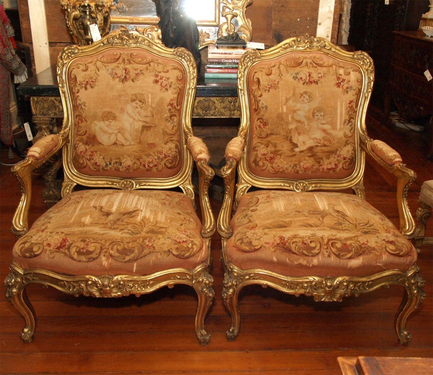 Pair of 19th c Louis XV style giltwood armchairs of amazing size and great carving. Aubusson is worn on the seat but backs are perfect.
