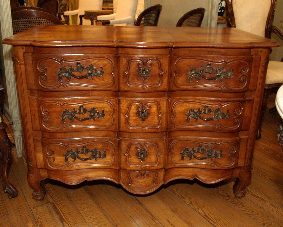 Period Louis XV walnut commod aux tombeaux with exceptional honey color and parquetry top. Great carving and form.