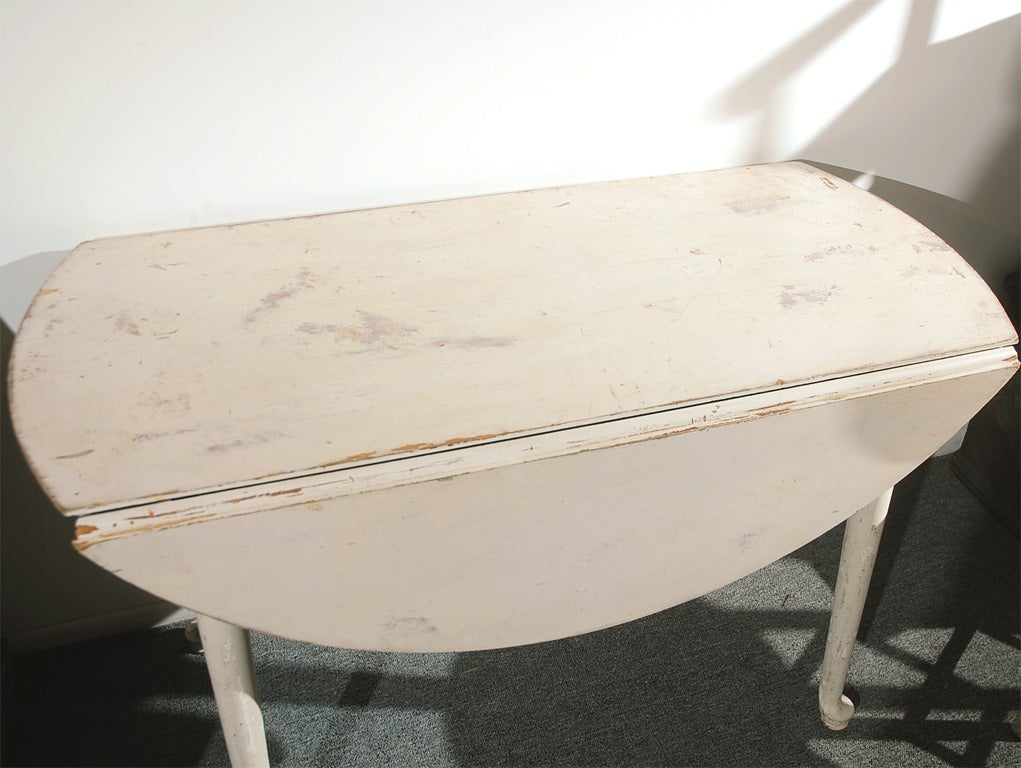 19THC ORIGINAL PAINTED DROP LEAF TABLE THAT OPENS TO A FULL ROUND TABLE.WONDERFUL FORM AND NICE DRY SURFACE.THIS SLEEK AND SIMPLE FORM TABLE HAS NICE QUEEN ANNE LEGS.