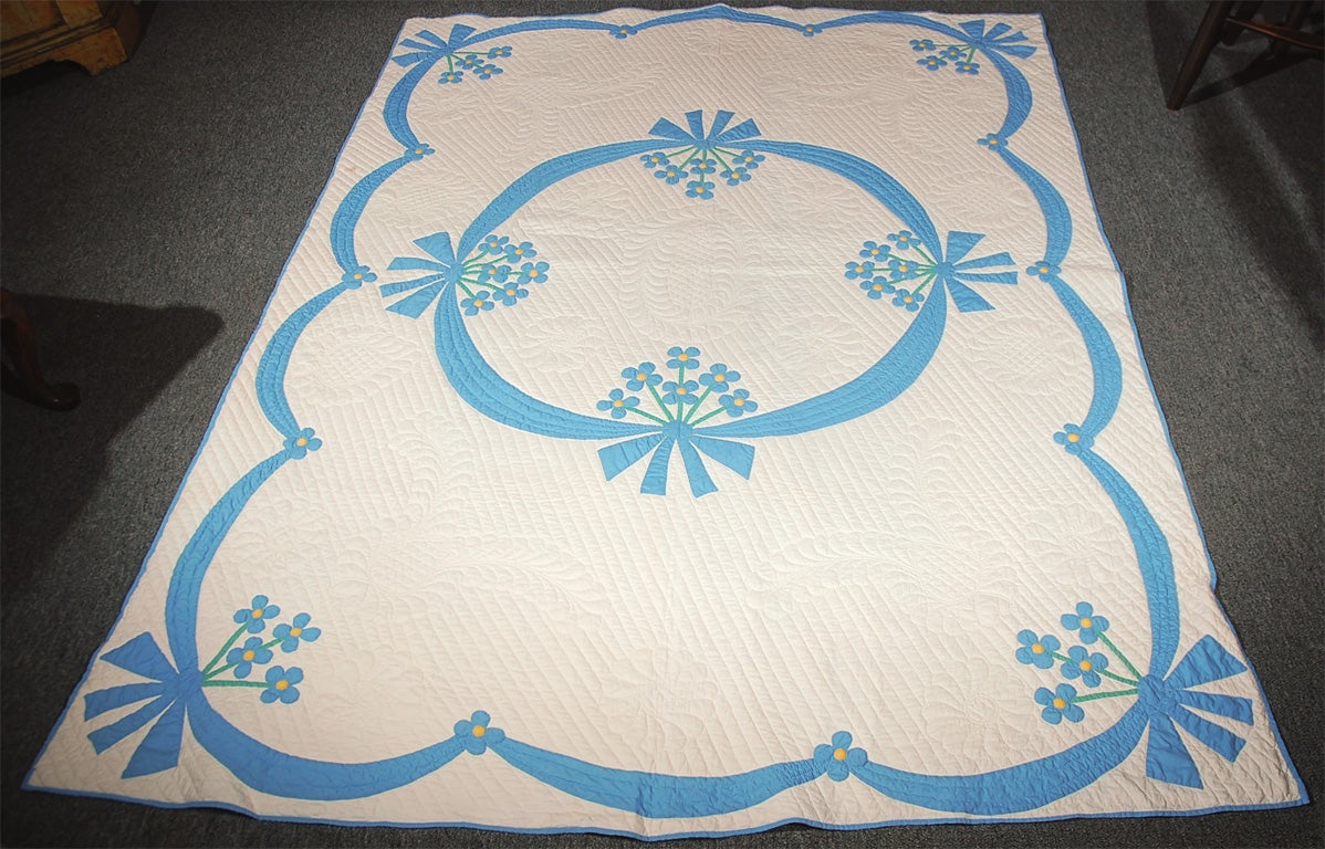 1920'S MARIE WEBSTER QUILT. BLUE AND WHITE FLOWER VINE WITH SWAG BORDER. GREAT TIGHT AND GOOD QUILTING.