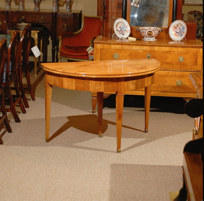 A Restoration period fruitwood demi-lune table with hinged flip-top and tapering legs, originating from France and dating the 1st half of the 19th century.  