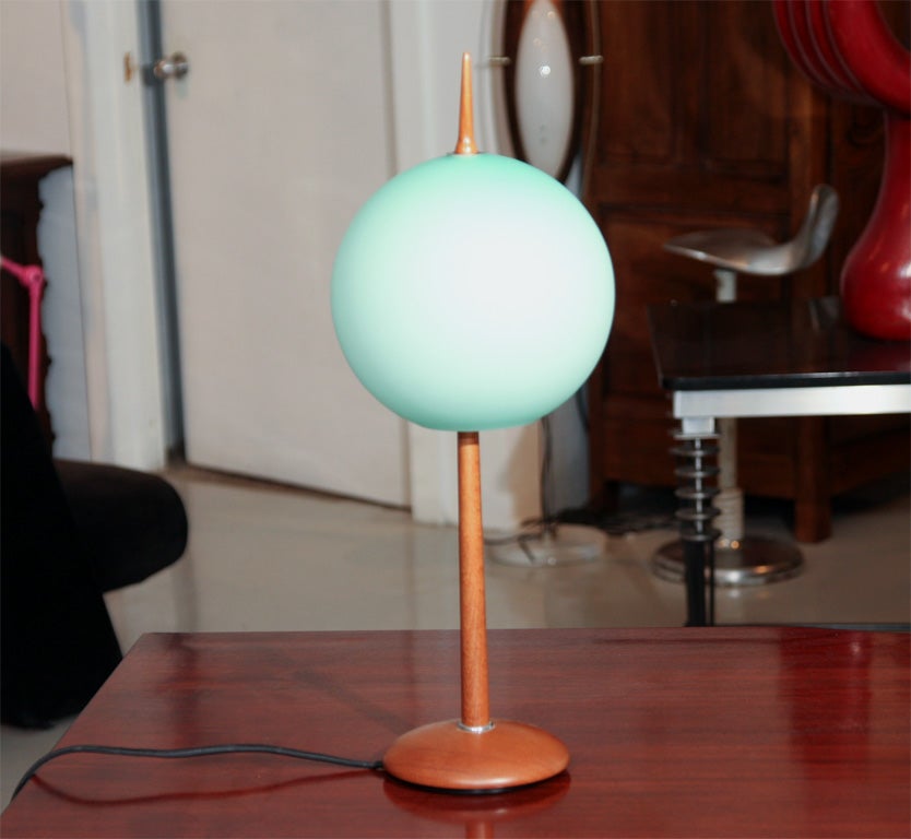 This unique pair of lamps have wooden bases and matte opaque teal globes.