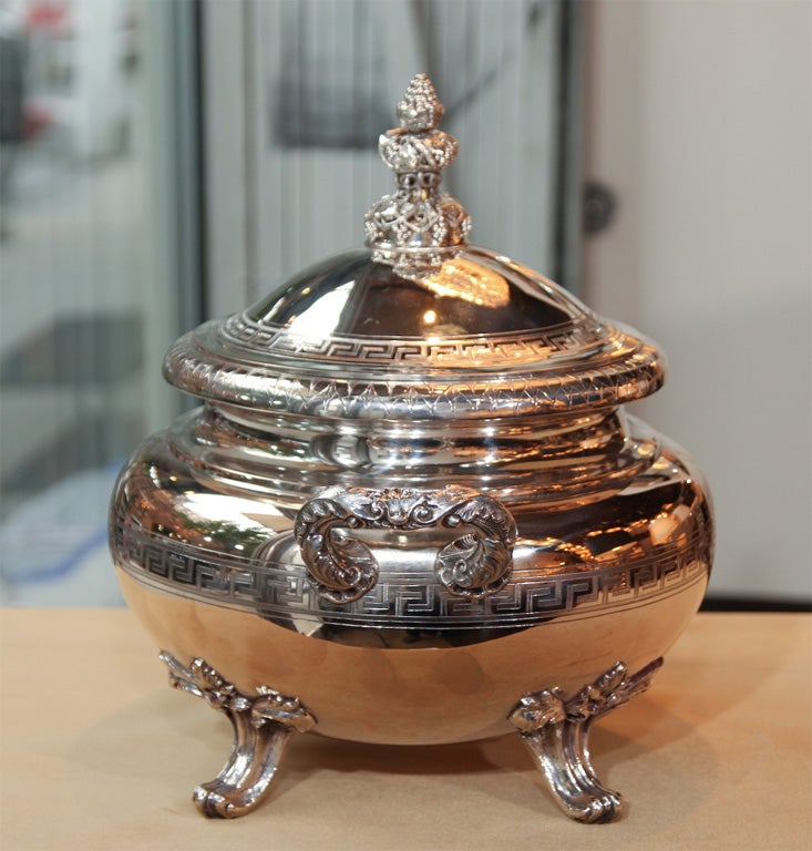 This gorgeous tureen was forged by Gebruder Friedlander circa 1875, one of Berlin's most renowned silversmiths at that time. The footed tureen features a chased Greek key pattern that circumscribes the rim of the lid and the body. The handle, feet,